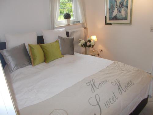 a white bed with a sign on it in a bedroom at Schlei-Rose in Kappeln