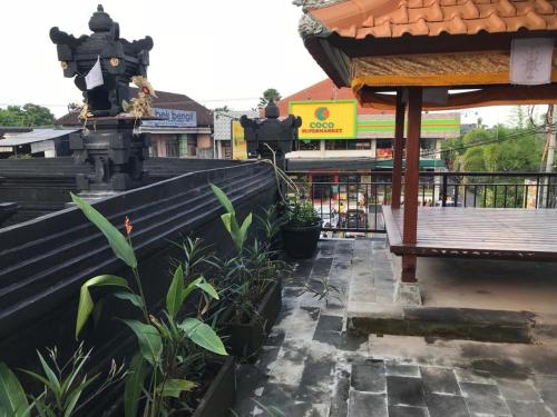 a bench sitting on the side of a building at Grey House Monkey Forest in Ubud