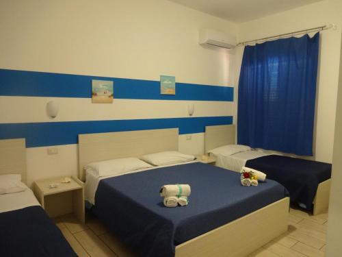 two beds in a room with blue and white walls at Il Vecchio Pescatore in Amendolara