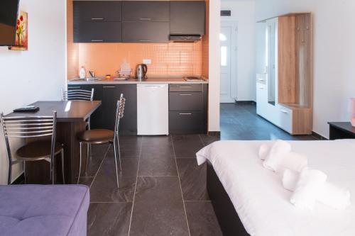 Alessandra Apartments في سفيتي ستيفان: مطبخ وغرفة نوم مع سرير وطاولة