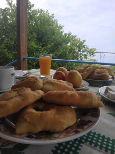 a table with plates of pastries and a glass of orange juice at Casa Qeparo in Qeparo