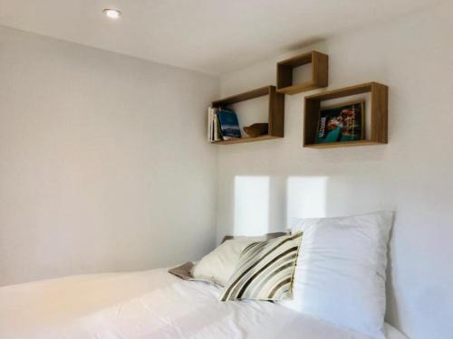 a bedroom with a bed with two shelves on the wall at Appartement cosy et chaleureux à Megève avec vue sur le Mont Blanc in Demi-Quartier