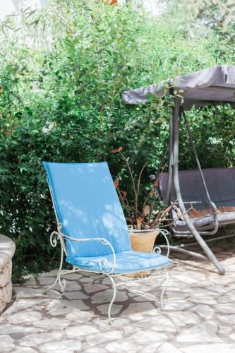 a blue chair sitting in front of a grill at Afroditi Pansion in Agios Nikitas