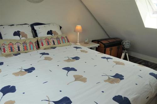 - une chambre avec un lit orné de fleurs bleues dans l'établissement LILWENN, à Guidel