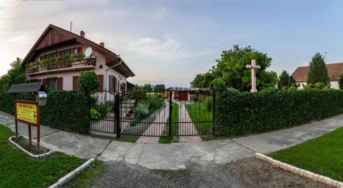 a house with a gate and a cross in front of it at Gemenc Vendégház in Hercegszántó