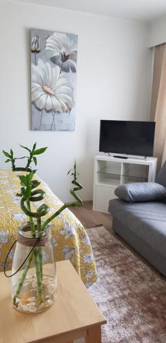 uma sala de estar com um vaso com uma planta sobre uma mesa em Suojalantie 4 em Heinävesi