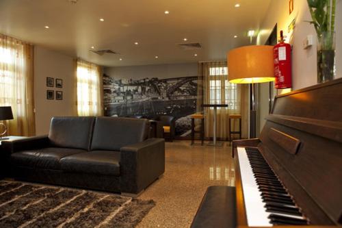 
a living room filled with furniture and a piano at Hotel Boa - Vista in Porto

