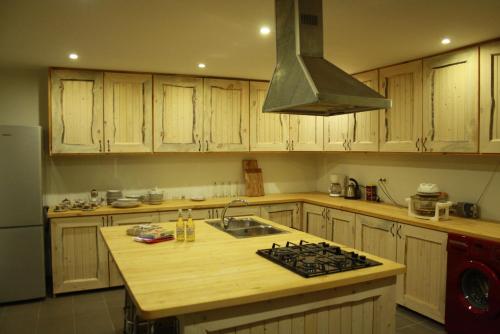 a kitchen with wooden cabinets and a stove top oven at Pedaja Puhketalu in Nulga