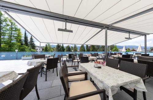 a restaurant with tables and chairs with a view at Hotel-Restaurant Grimmingblick in Bad Mitterndorf