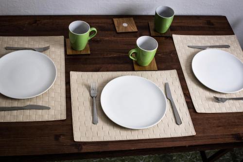 a table with white plates and utensils on it at Ubytování Na Jarošce in Hodonín