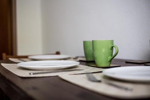 a wooden table with plates and a green coffee mug at Ubytování Na Jarošce in Hodonín