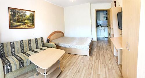 a living room with a couch and a bed and a table at Butai labai geroje vietoje prie juros in Palanga