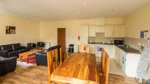 a kitchen and a living room with a wooden table at The Courtyard Apartments in Carrick on Shannon
