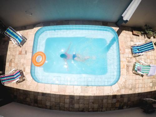 a person in a swimming pool with an orange frisbee at Meu Hostel in Maceió