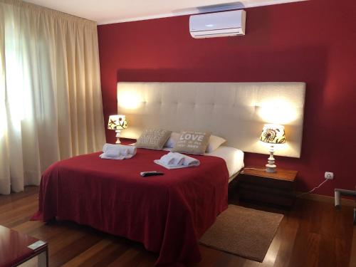 1 dormitorio rojo con 1 cama con 2 toallas en Luxury Chaves Village, en Farroupo