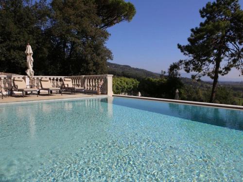 a large swimming pool with chairs and trees at Hotel Villa Casanova in Lucca
