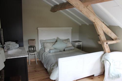 een slaapkamer met een wit bed en een wastafel bij Arc de l'amour in Youx