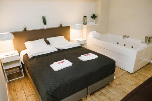 um quarto com uma cama grande e uma banheira em Apartman Donner Centar III em Subotica