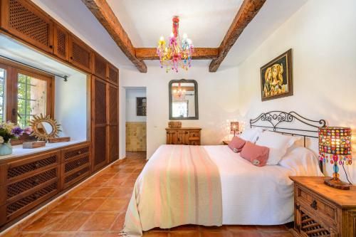 1 dormitorio con cama y lámpara de araña en Finca Niko, en Santa Eulària des Riu