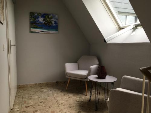 a room with two chairs and a table and a window at Hotel Kellermann in Overath