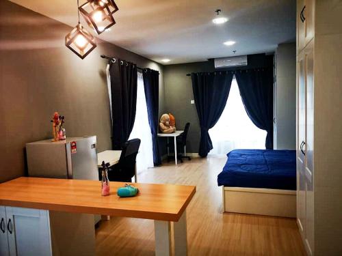 a bedroom with a bed and a table and a desk at Kampar Champs Elysees, King Bed Studio unit 12A21 in Kampar