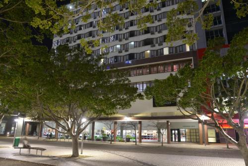 a building at night with trees in front of it at The Capetonian - Halal in Cape Town