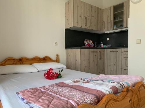 a bedroom with a bed with flowers on it at helios apartmenthouse in Olympiaki Akti
