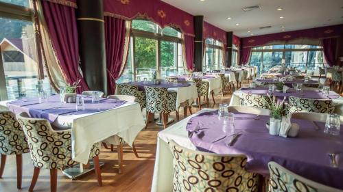 uma fila de mesas num restaurante com toalhas de mesa roxas em Sarot Termal Park Resort em Bolu