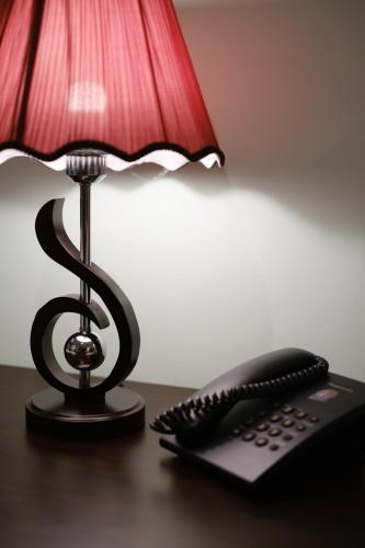 a lamp and a remote control sitting on a table next to a telephone at Grey House Monkey Forest in Ubud