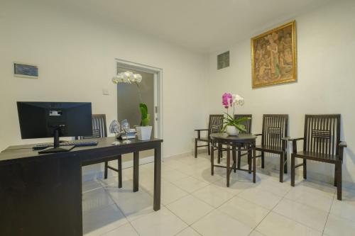 a room with a desk with a computer and chairs at Grey House Monkey Forest in Ubud