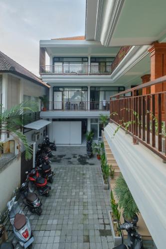 an external view of a house with motorcycles parked in a courtyard at Grey House Monkey Forest in Ubud