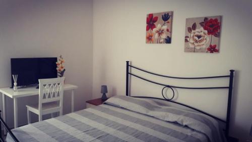 a bedroom with a bed and a desk and a television at Allegra B&B in Terracina