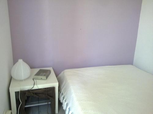ein Schlafzimmer mit einem Bett und einem Tisch mit einer Lampe in der Unterkunft appartement T1 BIS in Saint-Georges-dʼOrques