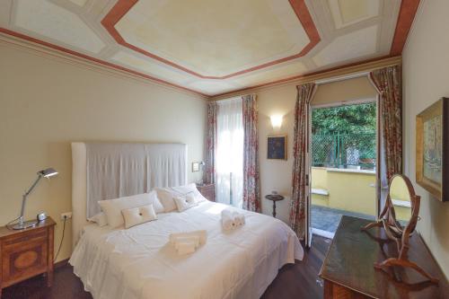 ein Schlafzimmer mit einem großen weißen Bett und einem Fenster in der Unterkunft VILLA AURORA Relax con Vista Mare e Piscina in Camogli