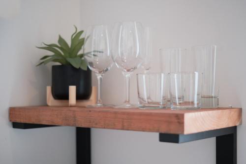 a wooden shelf with wine glasses on it at The Setting Inn Napa Valley in Napa