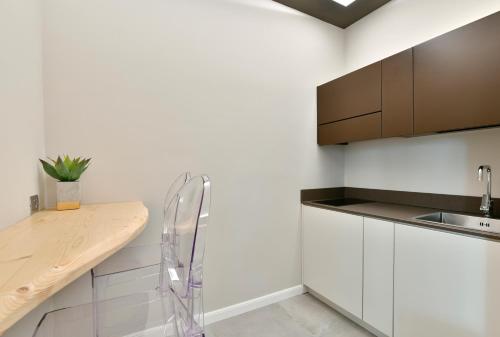 a kitchen with white cabinets and a wooden counter top at Amnis suites in Santa Maria di Castellabate