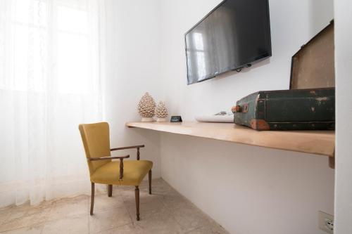 ノート・マリーナにあるBaglio Siciliamo Country Houseのデスク、椅子、テレビが備わる客室です。