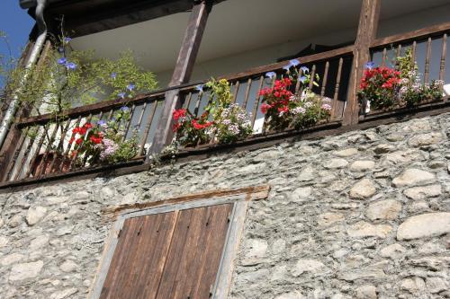 eine Steinmauer mit Blumenkästen auf dem Balkon in der Unterkunft Dolwin in Argelès-Gazost