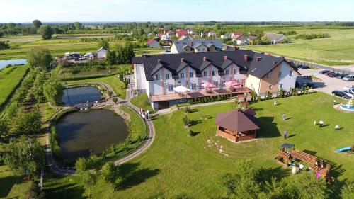 an aerial view of a large house with a lake at Hotel Restauracja LORENZO in Stopnica