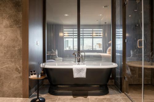 a bathroom with a bath tub and a shower at Dakota Manchester in Manchester