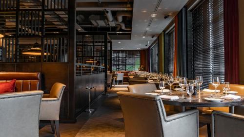 a restaurant with a long table and chairs at Dakota Manchester in Manchester