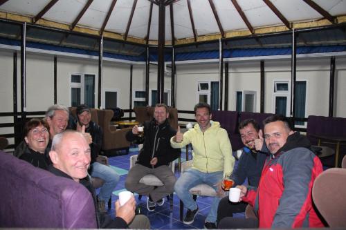 a group of people sitting in chairs holding wine glasses at Park Hostel Osh in Osh