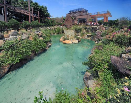 a pool of water in front of a building at Jin Yong Quan Spa Hotspring Resort in Wanli