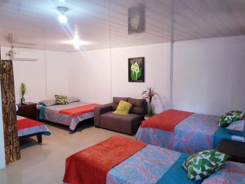 ein Zimmer mit 3 Betten und einem Sofa darin in der Unterkunft Hotel Maguey in Chilamate