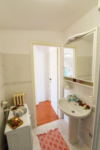 a white bathroom with a sink and a mirror at LA MANSARDINA VINTAGE in San Benedetto del Tronto