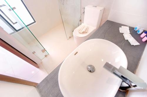 a bathroom with a white toilet and a sink at Phoenix Hotel Karon Beach in Karon Beach