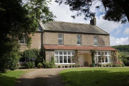 une grande maison en briques avec une grande cour dans l'établissement Anick Grange Farm B&B, à Hexham