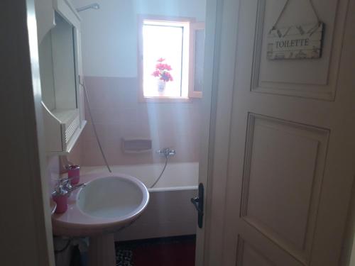 オートラントにあるDietro l'angoloのバスルーム(洗面台、トイレ付)、窓が備わります。