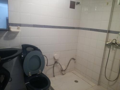La salle de bains est pourvue d'une douche et de toilettes. dans l'établissement Miramar, à Harhoura