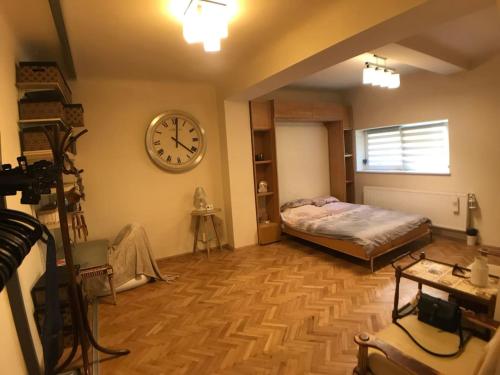 a room with a bed and a clock on the wall at Apartment Vintige in Cluj-Napoca